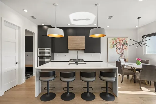 a kitchen with a sink and chairs