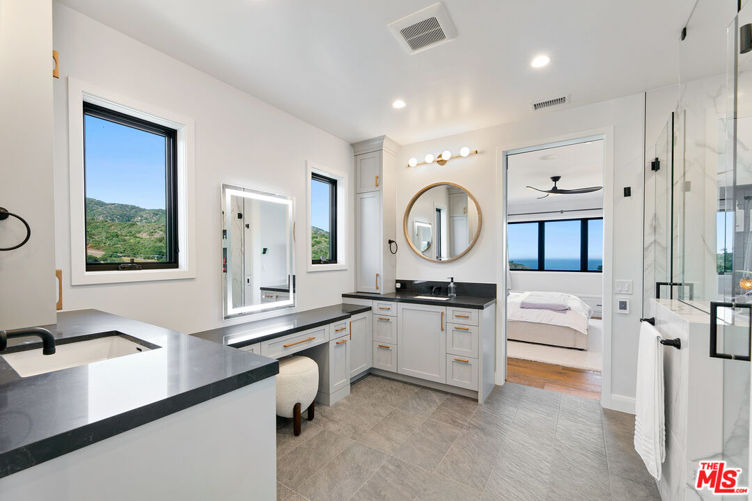 27148 Carrita Road Malibu, CA 90265 - Photo 11 of 27 a large white kitchen with a large window stainless steel appliances and furniture