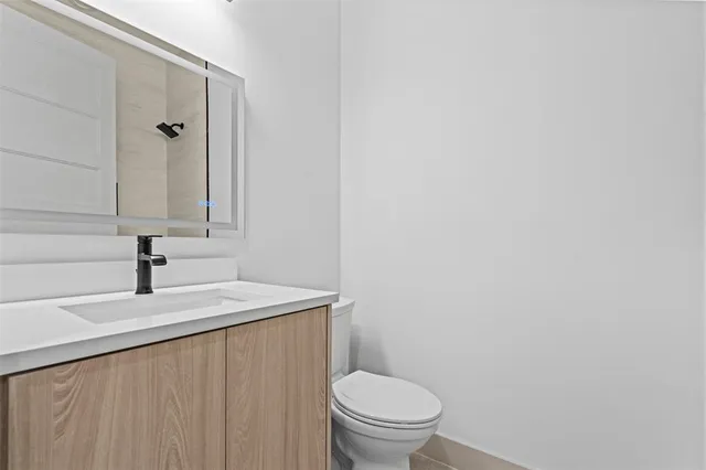 a bathroom with a sink a toilet and mirror