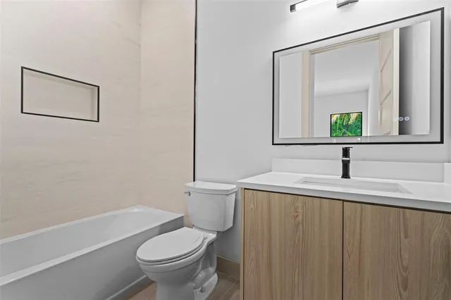 a bathroom with a granite countertop sink toilet and a mirror