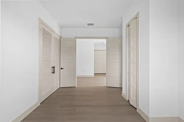 a view of a hallway with wooden floor
