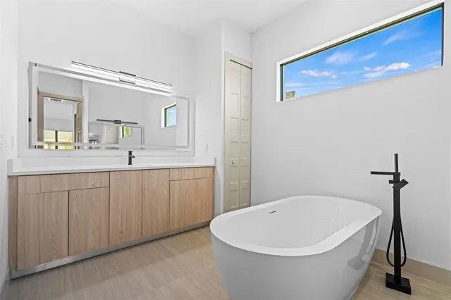 a white bath tub sitting next to a bathroom sink