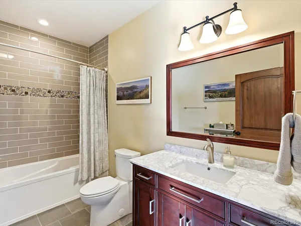 a bathroom with a granite countertop sink toilet and shower