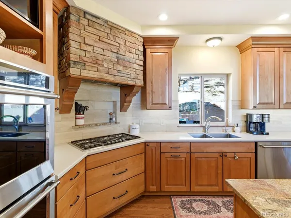 a kitchen with granite countertop a sink cabinets and stainless steel appliances