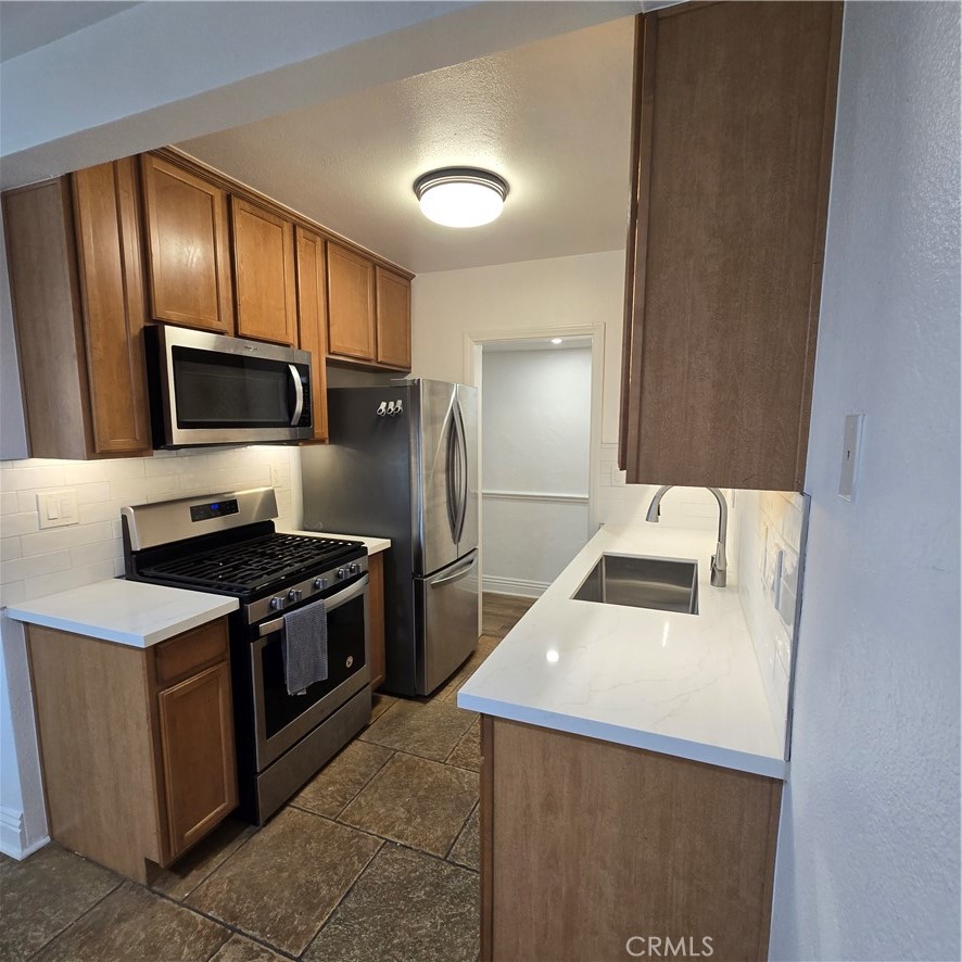 1440 West Lambert Road, Unit 233 La Habra, CA 90631 - Photo 8 of 26 a kitchen with stainless steel appliances granite countertop a refrigerator stove and sink