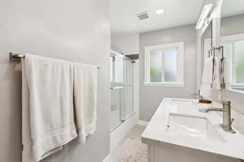 a bathroom with a sink tub and a mirror