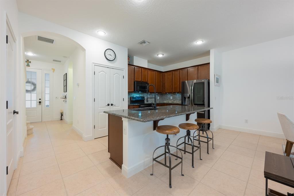 12305 Via Derna Place Windermere, FL 34786 - Photo 4 of 24 a kitchen with stainless steel appliances kitchen island granite countertop a refrigerator and a sink