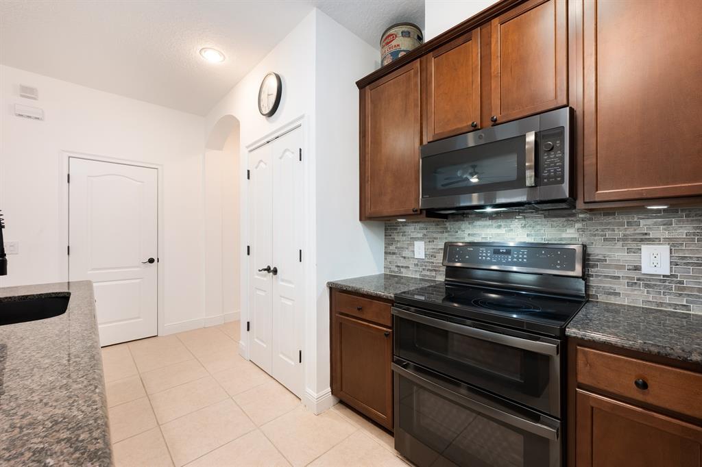 12305 Via Derna Place Windermere, FL 34786 - Photo 6 of 24 a kitchen with stainless steel appliances granite countertop a stove a microwave and a sink