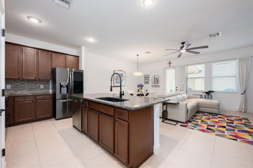 12305 Via Derna Place Windermere, FL 34786 - Photo 7 of 24 a kitchen with stainless steel appliances granite countertop a sink stove and refrigerator