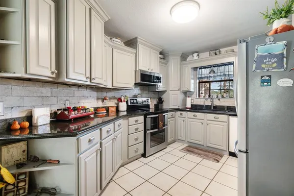 a kitchen with stainless steel appliances granite countertop a stove sink and cabinets