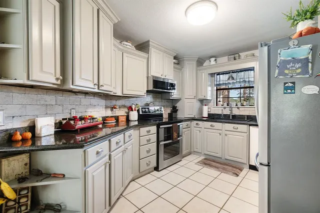 a kitchen with stainless steel appliances granite countertop a stove sink and cabinets