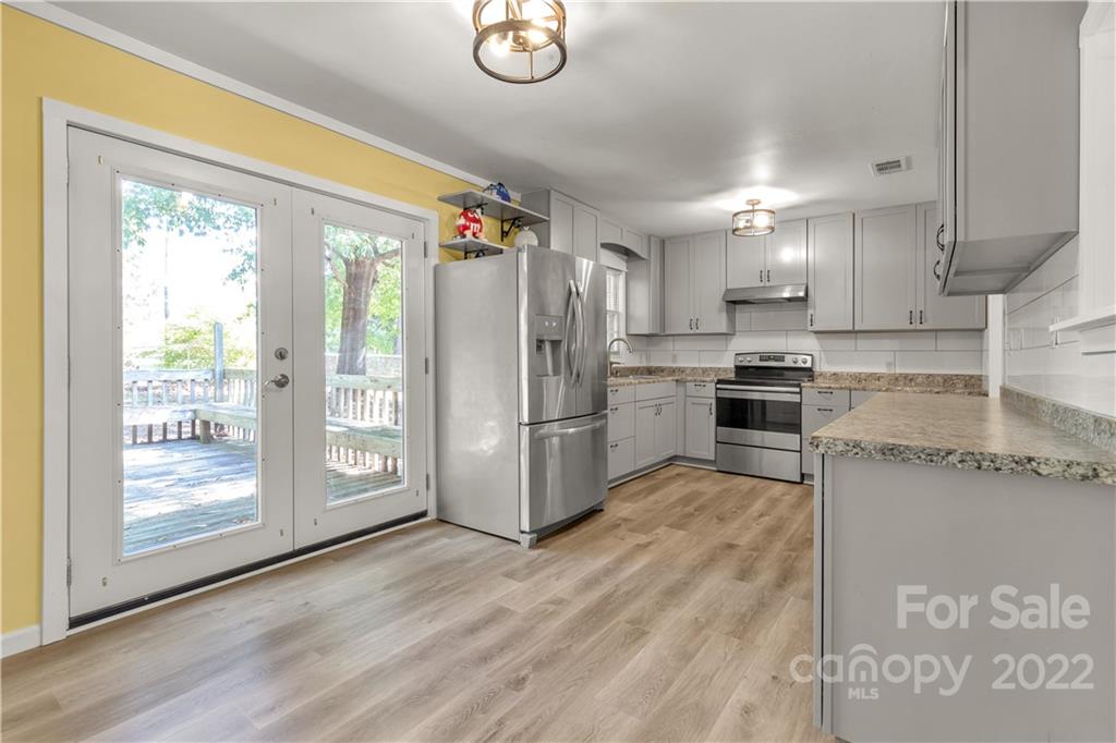 1909 John Everall Road Lancaster, SC 29720 - Photo 1 of 32 a kitchen with granite countertop a refrigerator a oven a sink and wooden floors