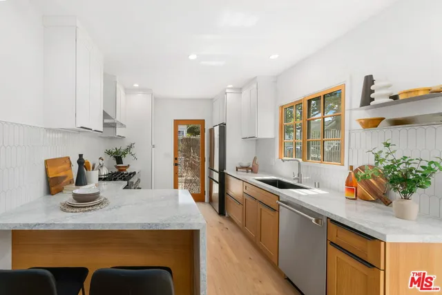 a kitchen with stainless steel appliances granite countertop a sink and a stove