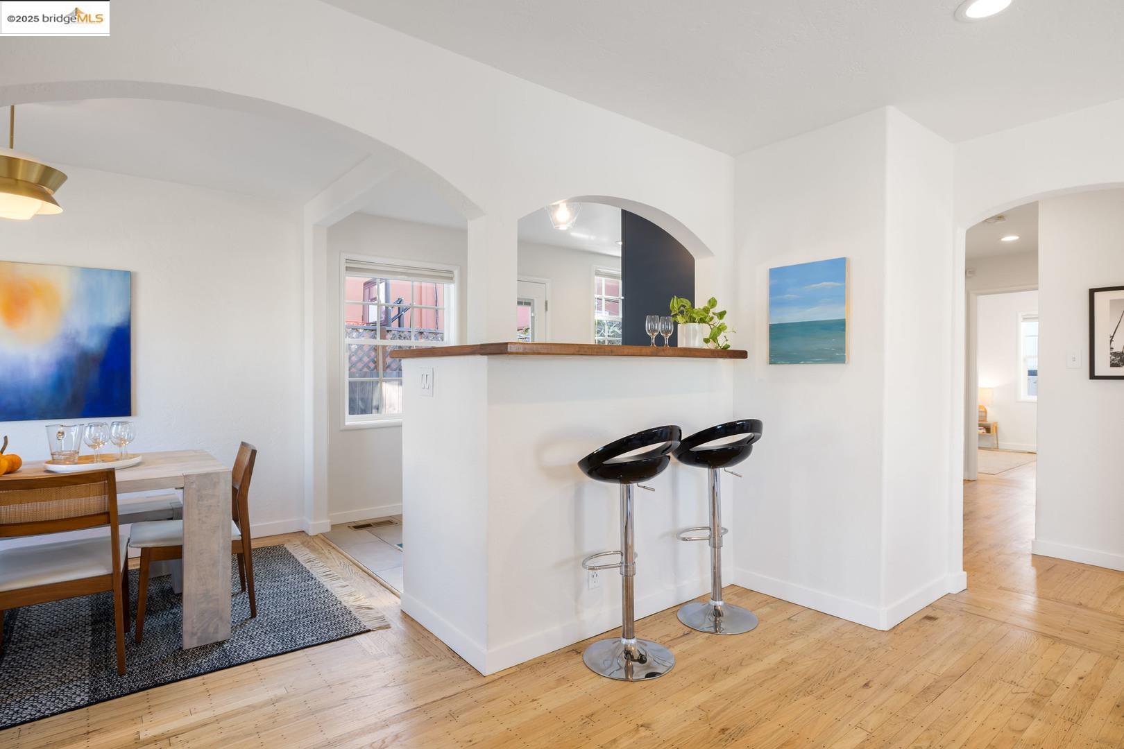 2829 California Street Berkeley, CA 94703 - Photo 7 of 20 a kitchen with stainless steel appliances a dining table chairs and a refrigerator a stove top oven with wooden floor