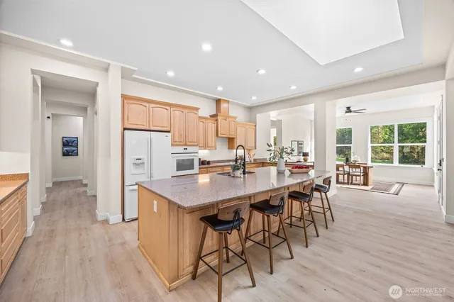 a kitchen with stainless steel appliances a dining table chairs and wooden floor