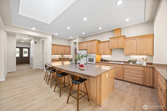 a kitchen with stainless steel appliances granite countertop table chairs sink and cabinets
