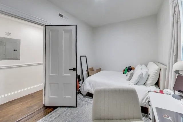 a bedroom with a bed and wooden floor