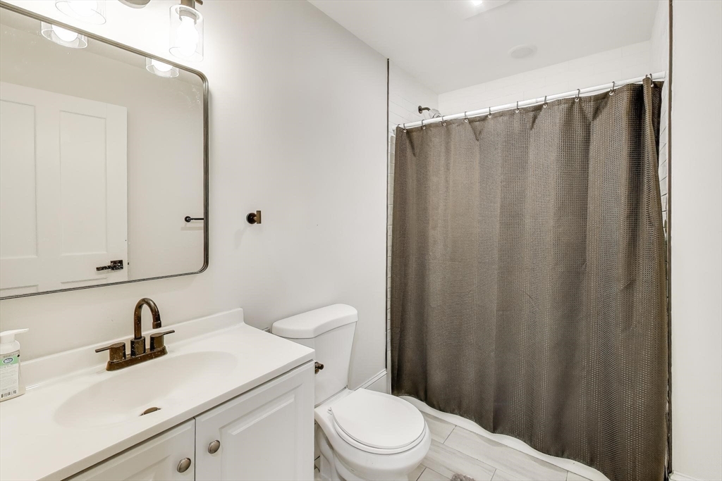 65 Lambert Avenue Boston, MA 02119 - Photo 27 of 42 a bathroom with a sink a toilet and shower
