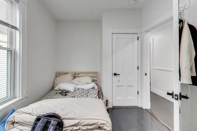 a bedroom with a bed and a window