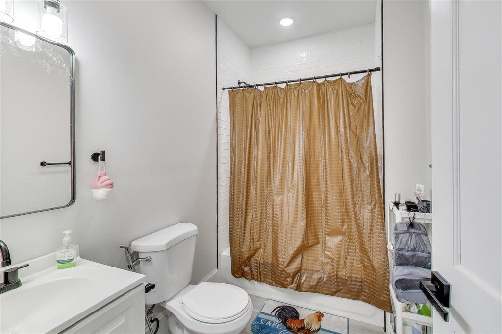 65 Lambert Avenue Boston, MA 02119 - Photo 39 of 42 a bathroom with a toilet and shower curtain
