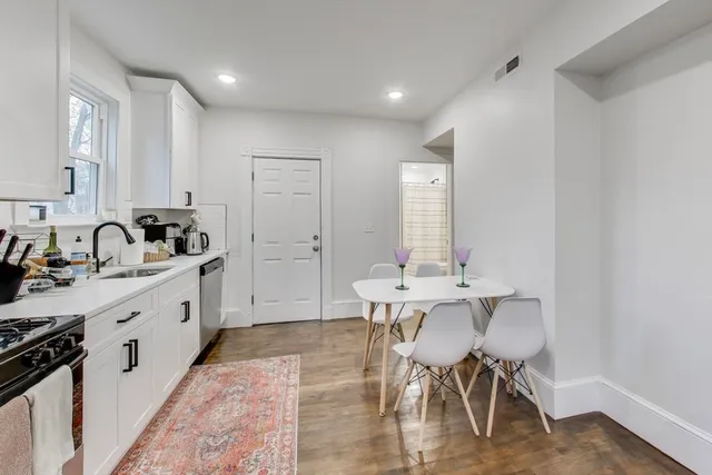 a large white kitchen with sink and cabinets
