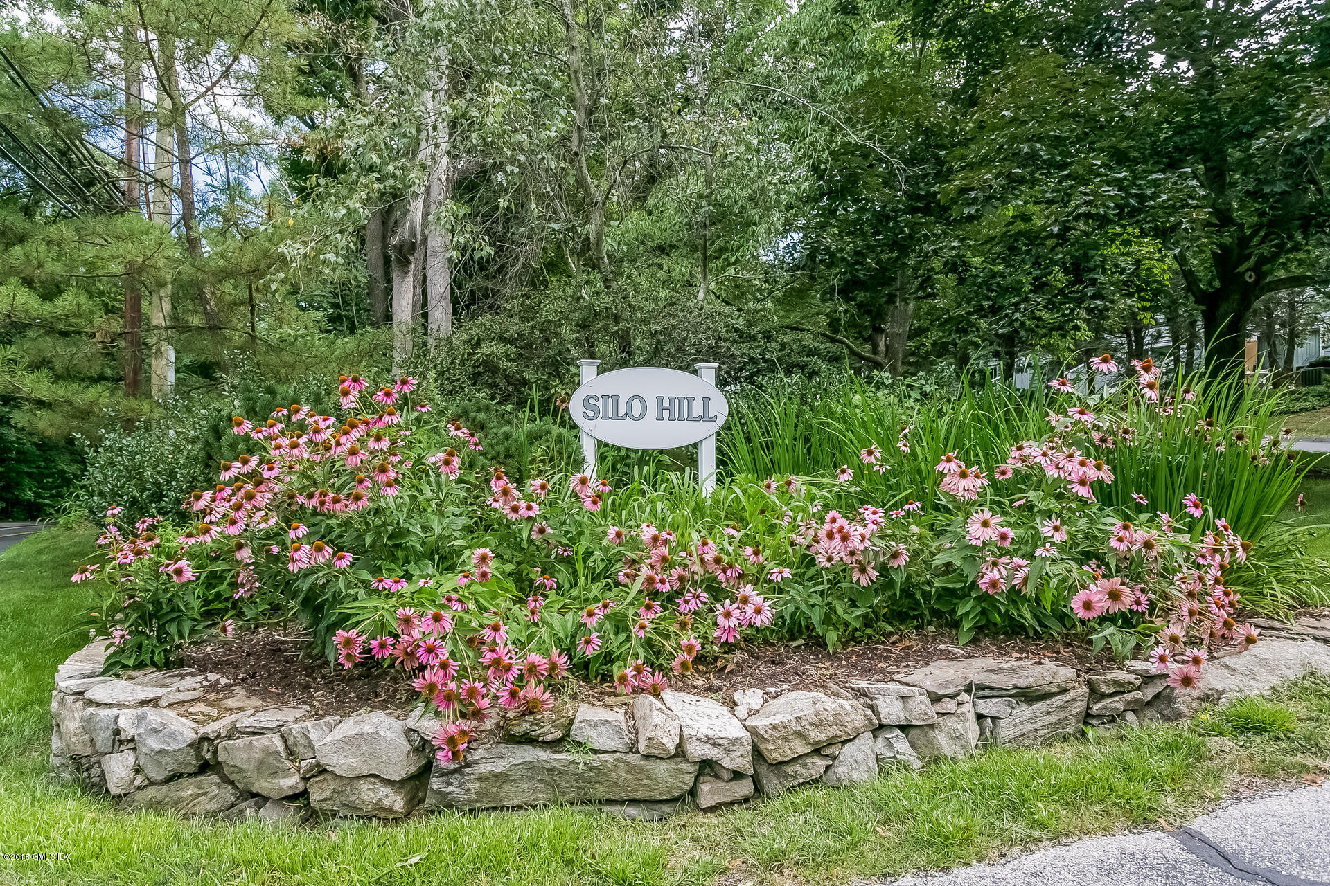 52 Stirrup Lane, Unit 52 Riverside, CT 06878 - Photo 1 of 30 a wooden fence with some plants in the back yard
