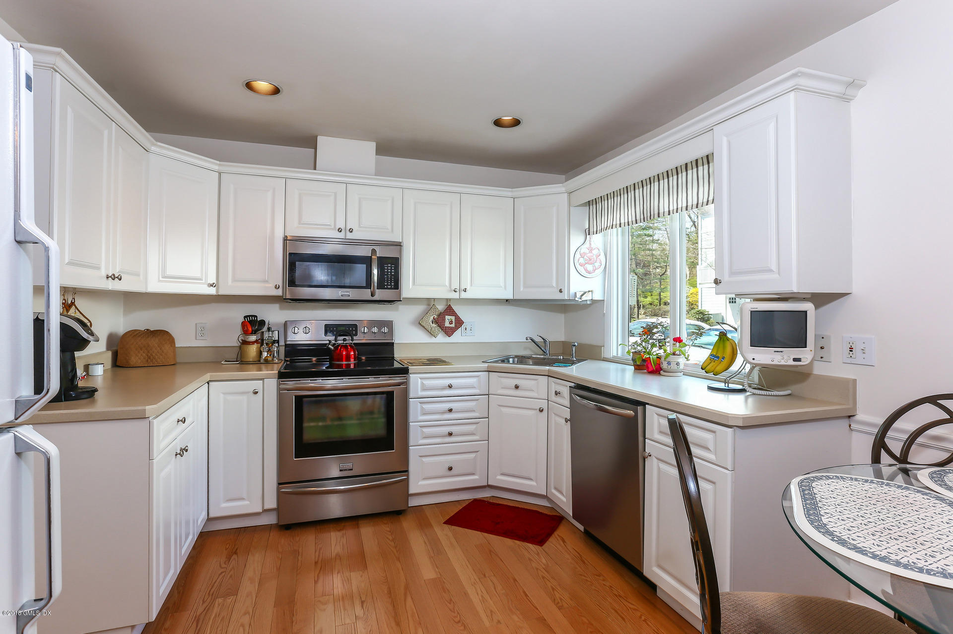 52 Stirrup Lane, Unit 52 Riverside, CT 06878 - Photo 8 of 30 a kitchen with granite countertop a sink cabinets stainless steel appliances and a window