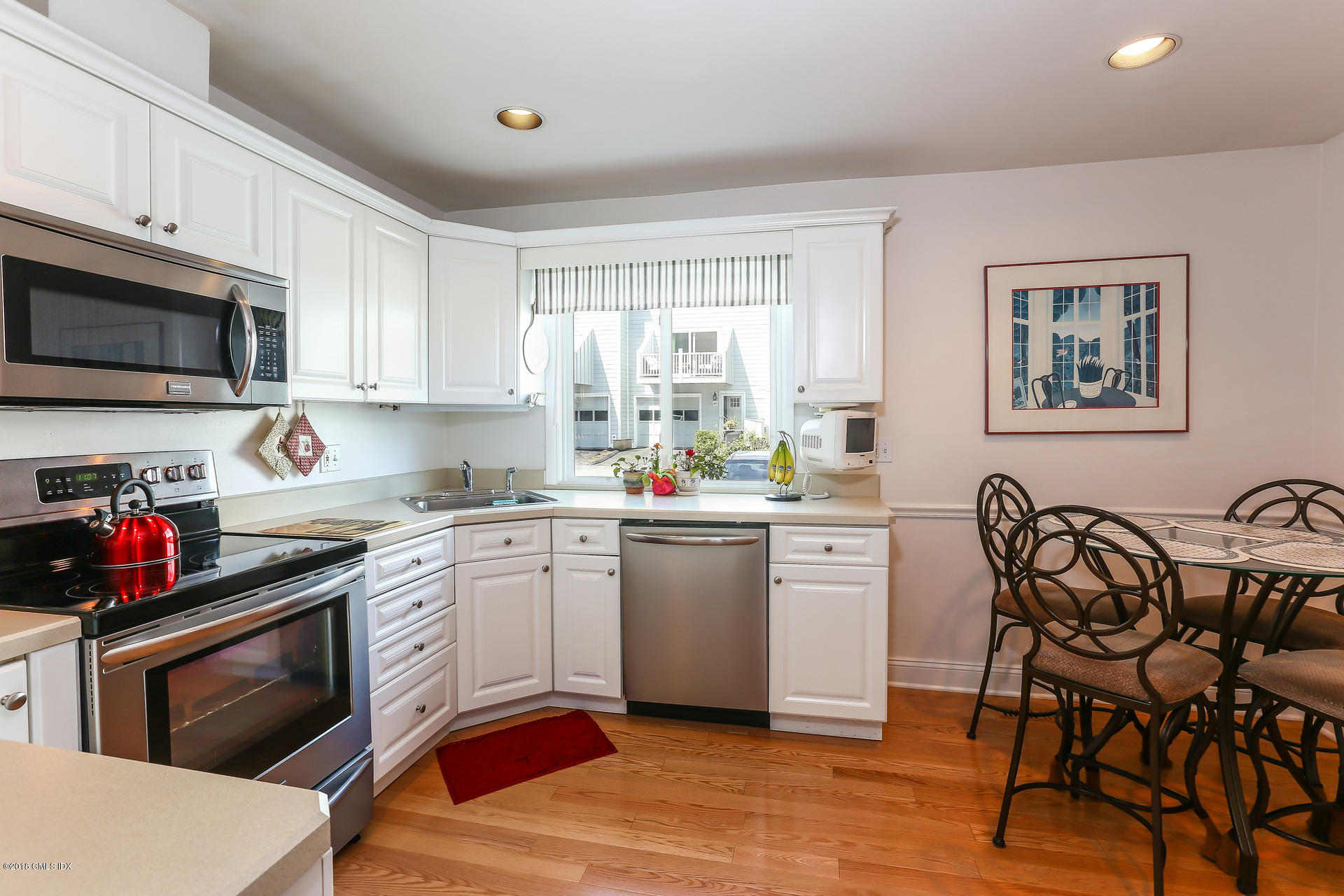 52 Stirrup Lane, Unit 52 Riverside, CT 06878 - Photo 10 of 30 a kitchen with white cabinets and appliances