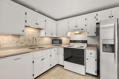 a kitchen with cabinets appliances and a sink