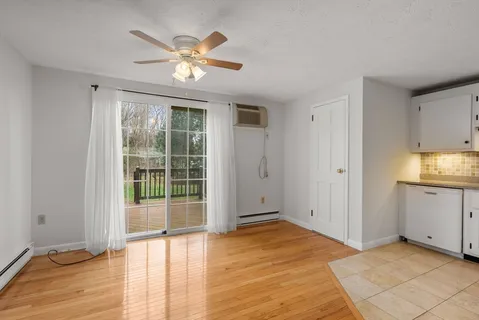 a view of an empty room with window and wooden floor