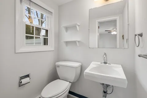 a bathroom with a toilet a sink and mirror
