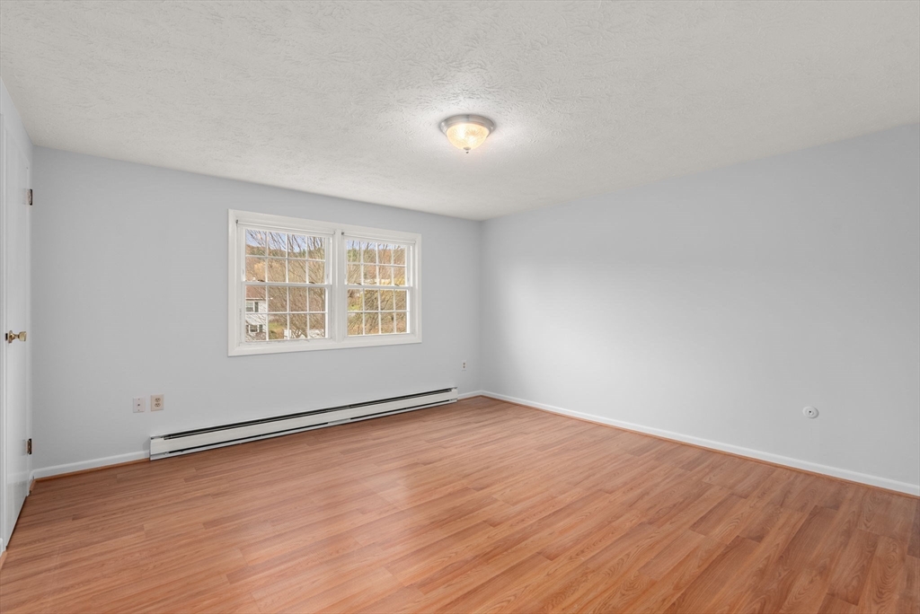 6 Keegan Lane, Unit E Greenfield, MA 01301 - Photo 18 of 29 an empty room with wooden floor and windows