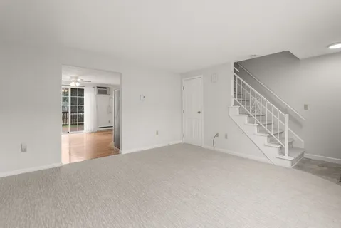a view of an empty room with chandelier fan