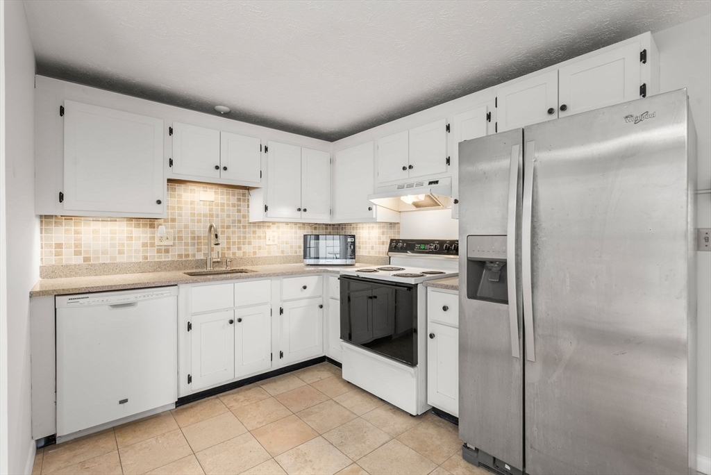 6 Keegan Lane, Unit E Greenfield, MA 01301 - Photo 10 of 29 a kitchen with granite countertop white cabinets and white stainless steel appliances