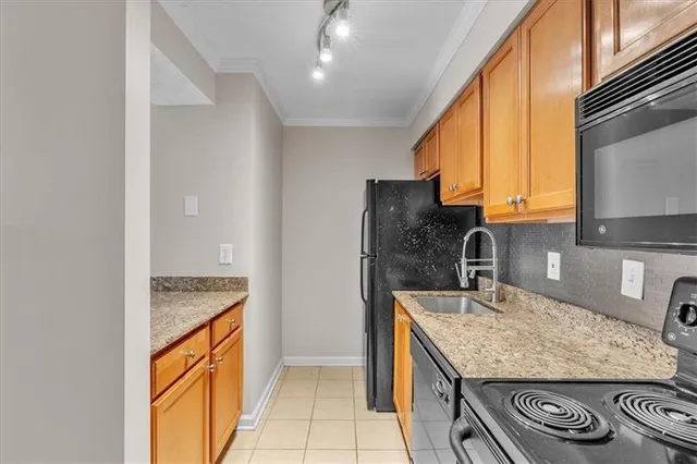 a kitchen with stainless steel appliances granite countertop a sink and a refrigerator
