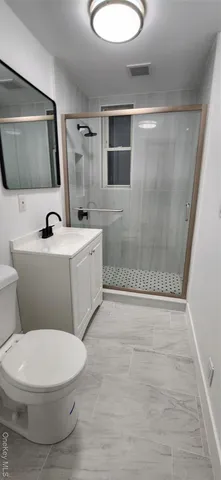a view of an empty room with wooden floor and chandelier