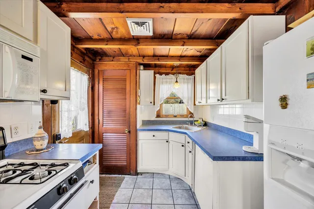 a view of a kitchen with fridge and workspace