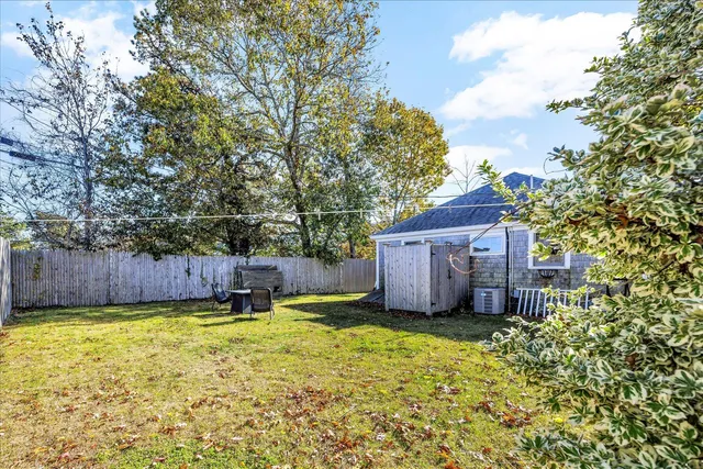 a view of a backyard with potted plants and large tree