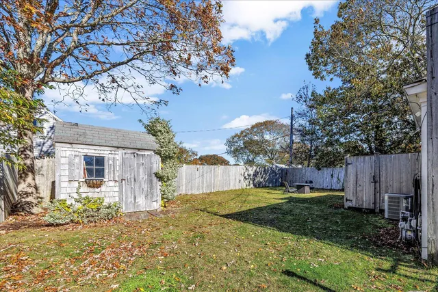 a view of a house with backyard and tree