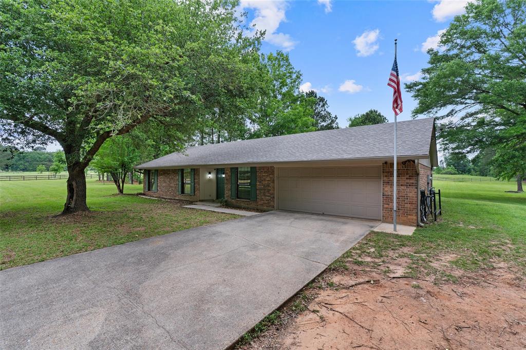 9720 Locust Hill Road Greenwood, LA 71033 - Photo 9 of 31 a front view of a house with a yard and garage
