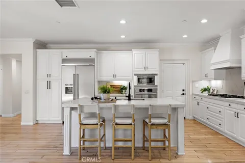a kitchen with granite countertop a table chairs stove and cabinets