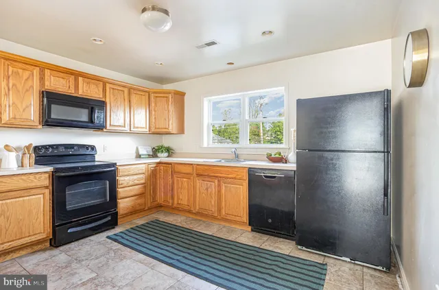 a kitchen with granite countertop a refrigerator stove and sink