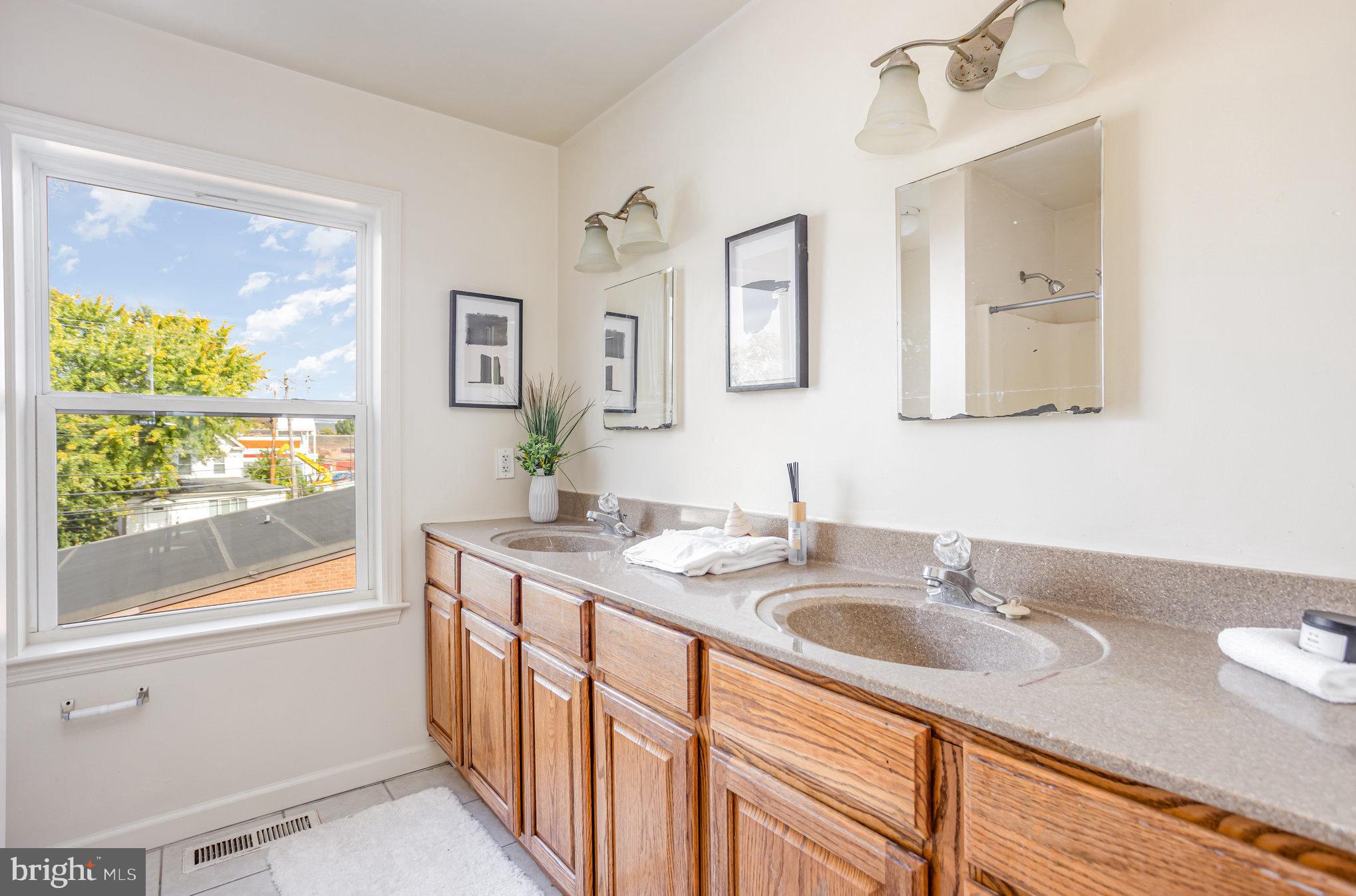 5237 Crowson Avenue, Unit 7 Baltimore, MD 21212 - Photo 8 of 18 a bathroom with a sink double vanity and a window