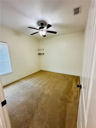 a view of room with a ceiling fan and window