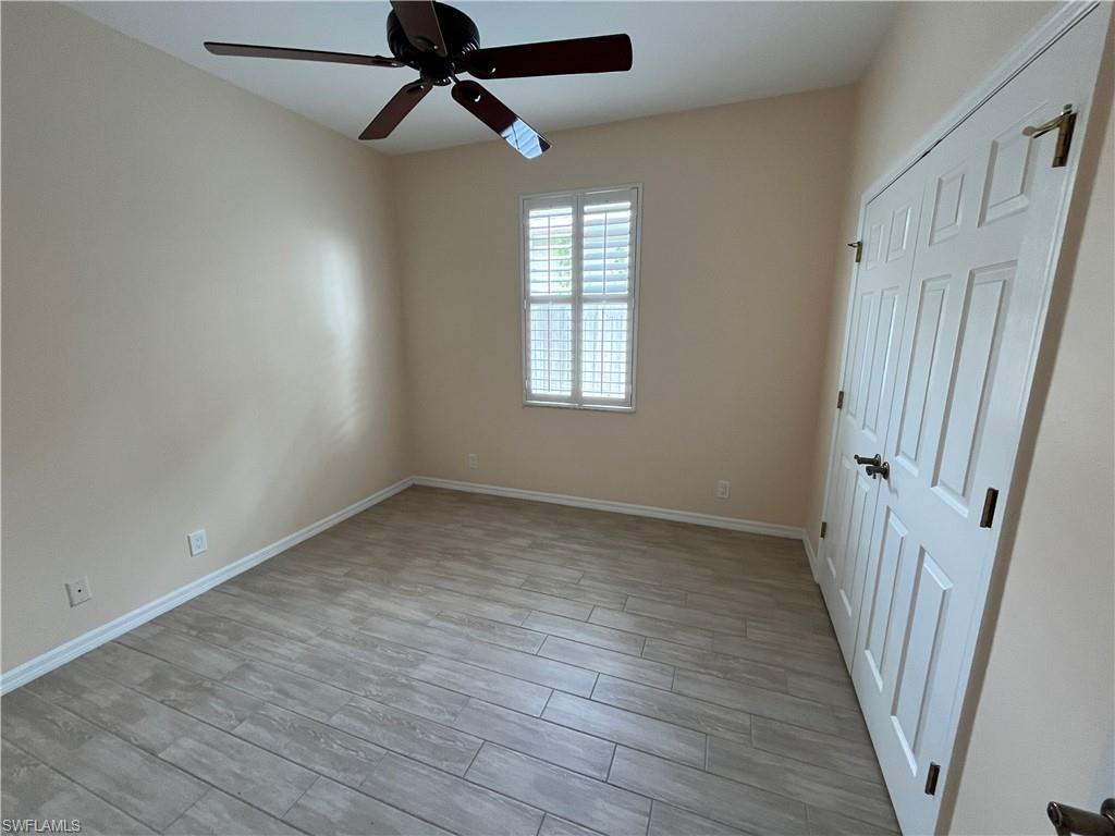 366 Burnt Pine Drive Naples, FL 34119 - Photo 16 of 36 wooden floor in an empty room with a window