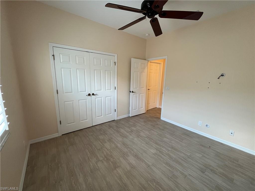 366 Burnt Pine Drive Naples, FL 34119 - Photo 17 of 36 an empty room with wooden floor closet and windows