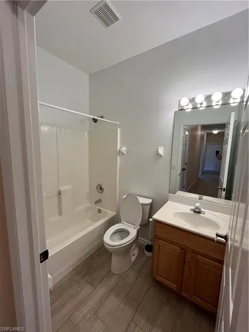 a bathroom with a double vanity sink toilet mirror and bathtub