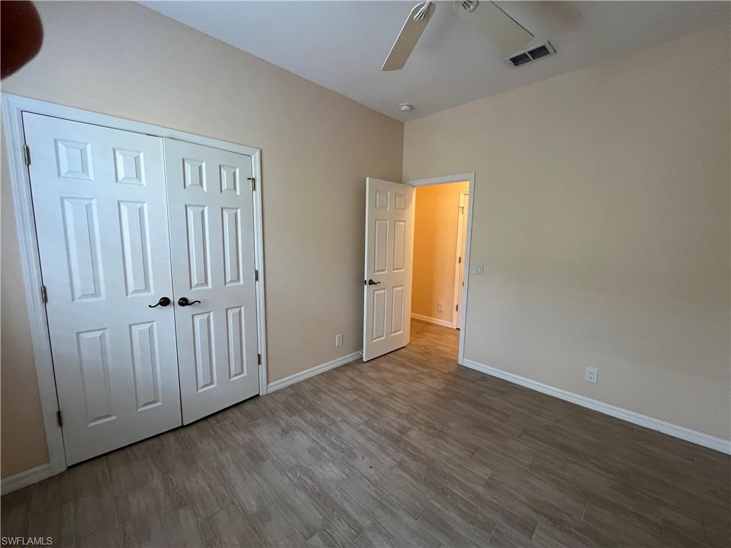 366 Burnt Pine Drive Naples, FL 34119 - Photo 20 of 36 an empty room with wooden floor and a window