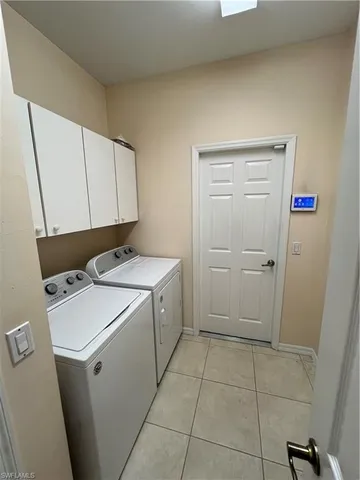 a utility room with cabinets washer and dryer