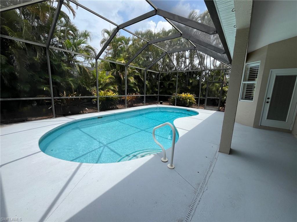 366 Burnt Pine Drive Naples, FL 34119 - Photo 27 of 36 a view of a swimming pool with a patio and yard